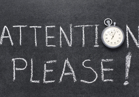 attention, please exclamation handwritten on chalkboard with vintage precise stopwatch used instead of O